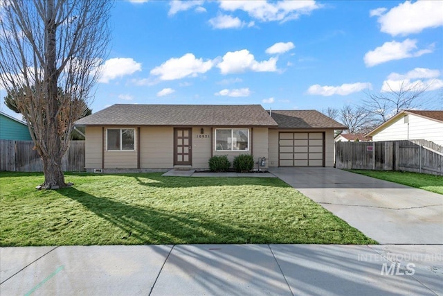 ranch-style home with a garage, concrete driveway, a front lawn, and fence