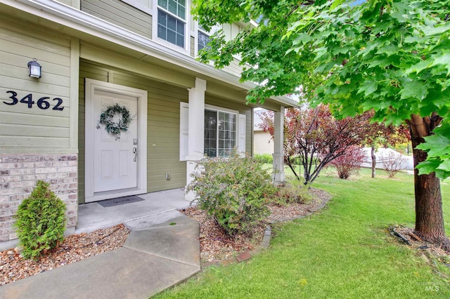 property entrance with a lawn