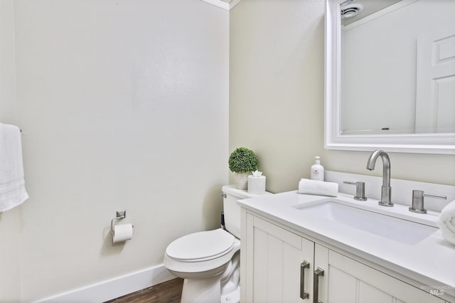 bathroom featuring crown molding, toilet, vanity, and hardwood / wood-style flooring