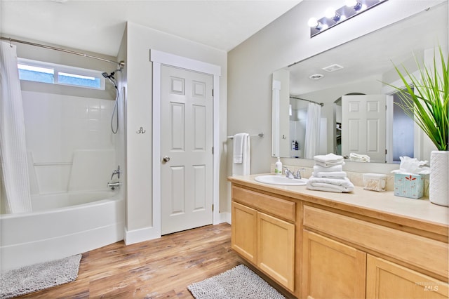 bathroom with hardwood / wood-style floors, shower / bath combo, and vanity