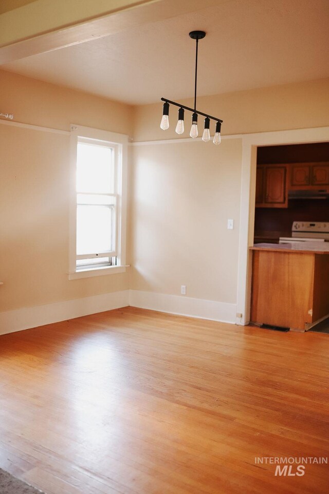 interior space featuring white range with electric stovetop, light hardwood / wood-style floors, and decorative light fixtures