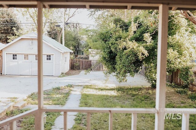 view of yard featuring a garage and an outbuilding
