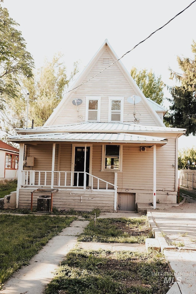 farmhouse inspired home featuring central AC and a porch