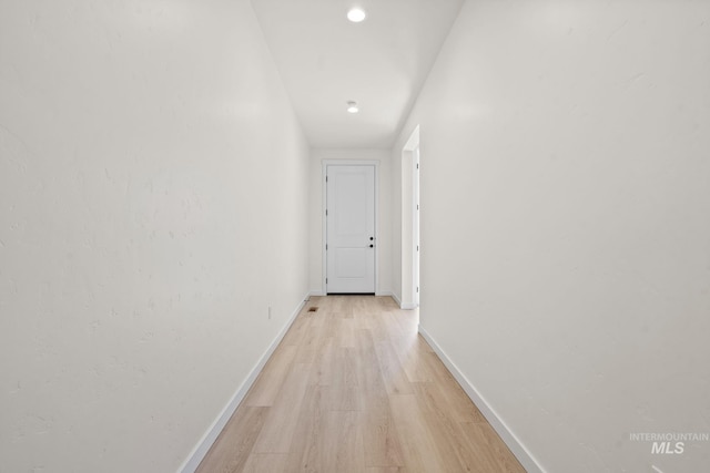 hallway featuring baseboards and light wood-style flooring