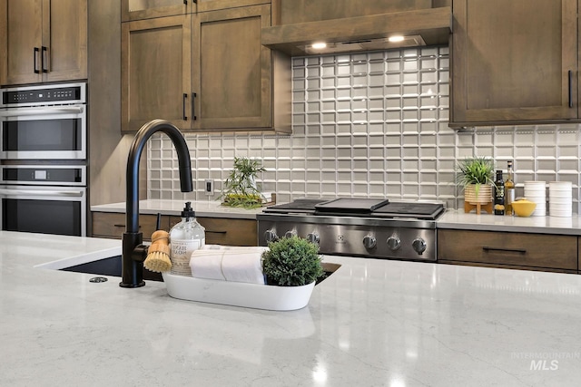 2493 E Galleon Ln, Meridian, ID 83642 - kitchen featuring range, double oven, ventilation hood, and tasteful backsplash