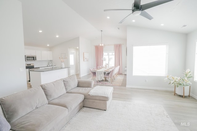 6073 W Mikonos St, Meridian, ID 83646 - living room with vaulted ceiling, light wood-style flooring, a ceiling fan, recessed lighting, and baseboards