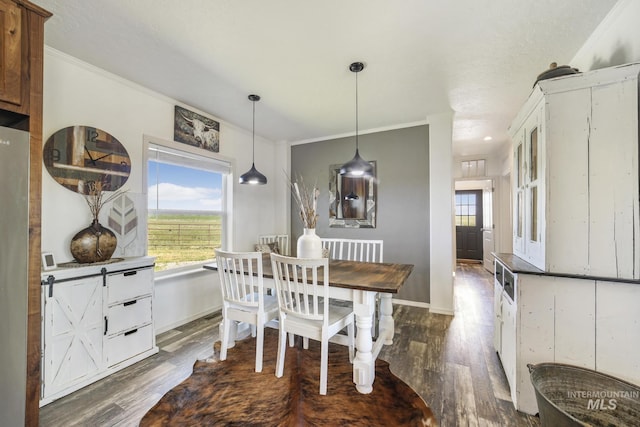 dining area with baseboards, ornamental molding, and dark wood-style flooring