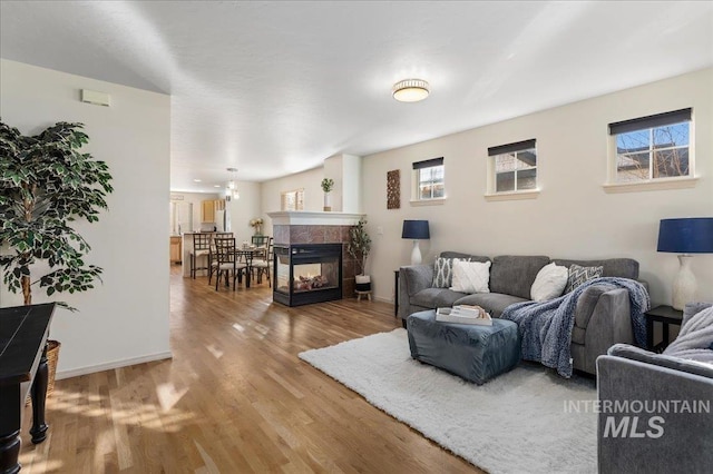living area featuring baseboards, wood finished floors, and a tile fireplace