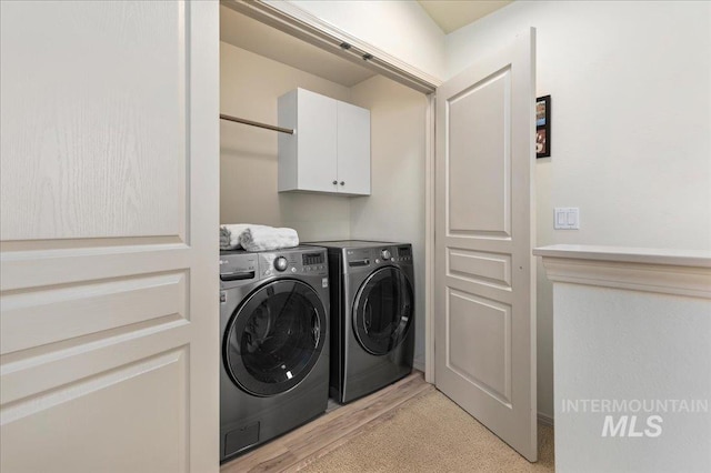 laundry room with separate washer and dryer and cabinet space