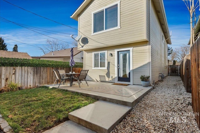 back of property featuring a fenced backyard, a lawn, and a patio area