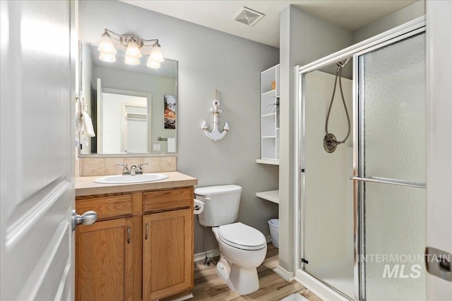 bathroom with visible vents, a stall shower, toilet, and vanity