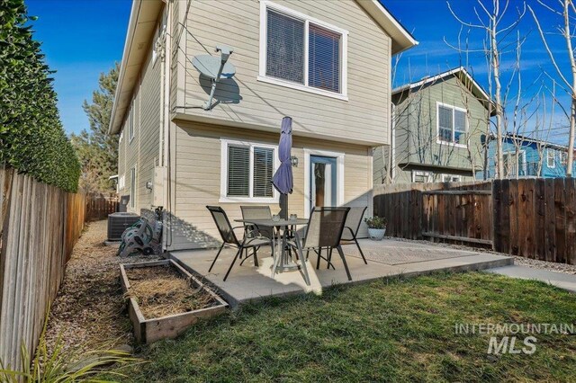 rear view of house featuring a garden, cooling unit, a fenced backyard, a patio area, and a yard