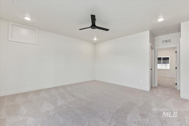 spare room featuring light colored carpet and ceiling fan