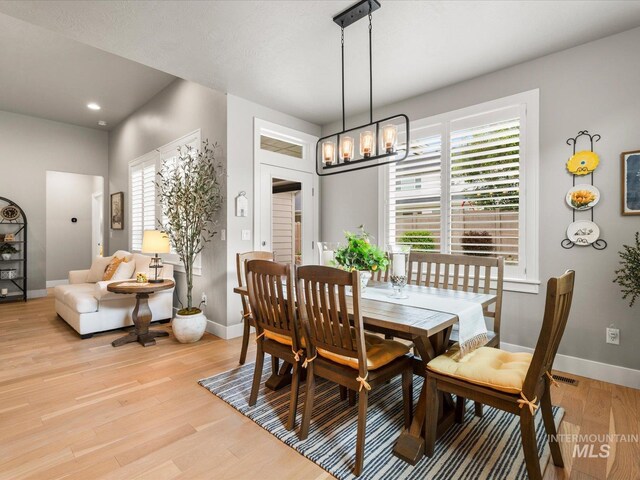 dining room featuring baseboards, light wood-style flooring, healthy amount of natural light, a chandelier, and recessed lighting