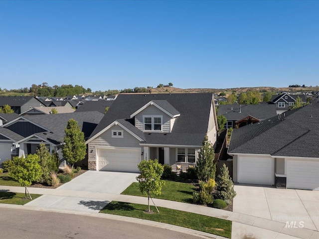 view of front of house featuring driveway, a residential view, and an attached garage