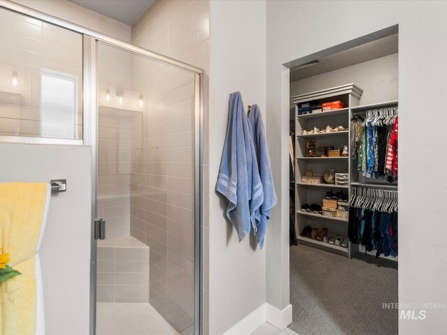 bathroom with a stall shower and a walk in closet