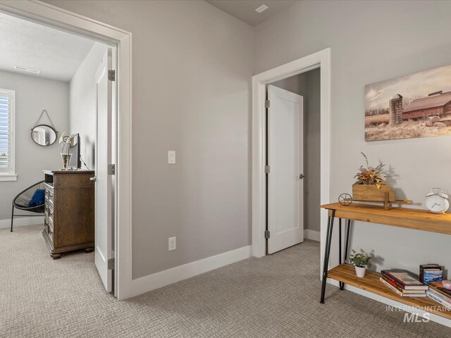 hallway with light carpet and baseboards