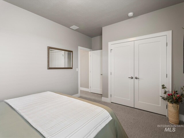 bedroom featuring light carpet, baseboards, and a closet