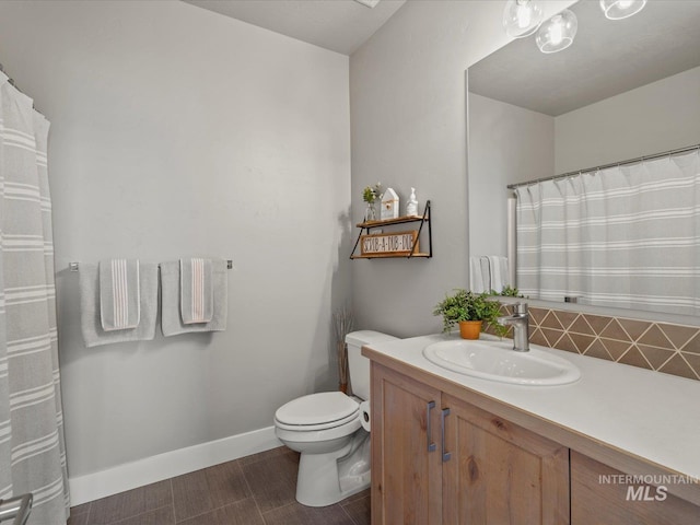 bathroom with toilet, vanity, baseboards, wood finished floors, and decorative backsplash