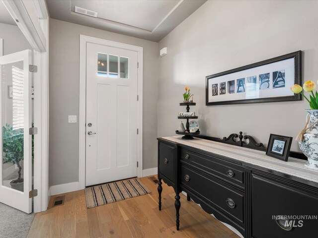 foyer featuring light wood-style floors and baseboards