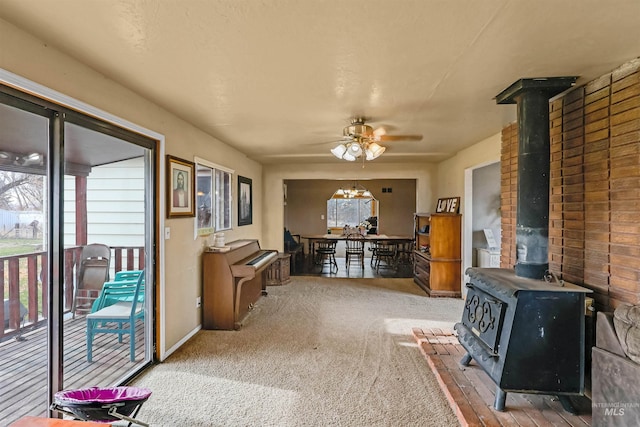 interior space with a wood stove and ceiling fan