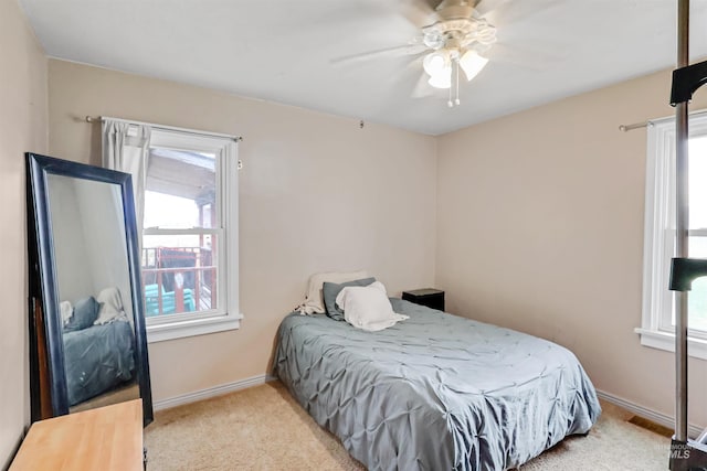 carpeted bedroom with ceiling fan and multiple windows