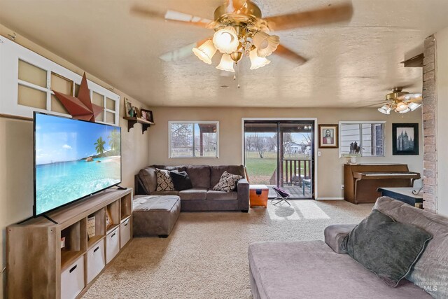 living room with a textured ceiling, ceiling fan, and light carpet