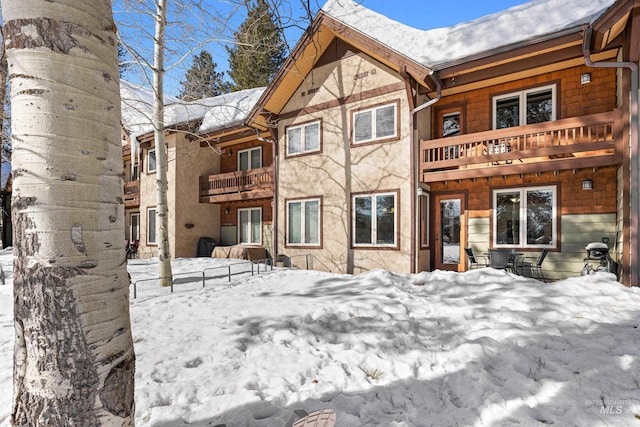 snow covered property with a balcony