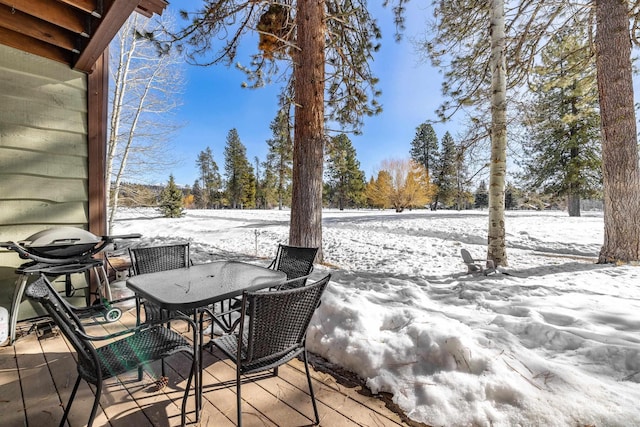 snow covered deck featuring outdoor dining space