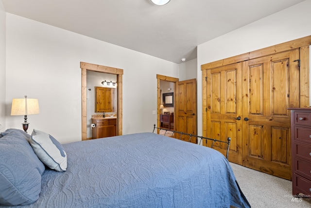 carpeted bedroom featuring ensuite bath