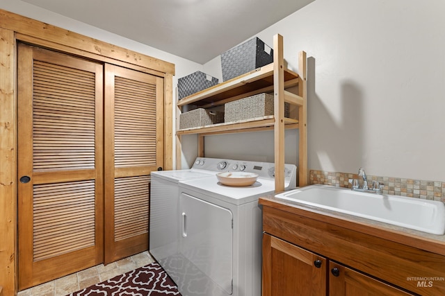 laundry area with cabinet space, a sink, and washer and clothes dryer