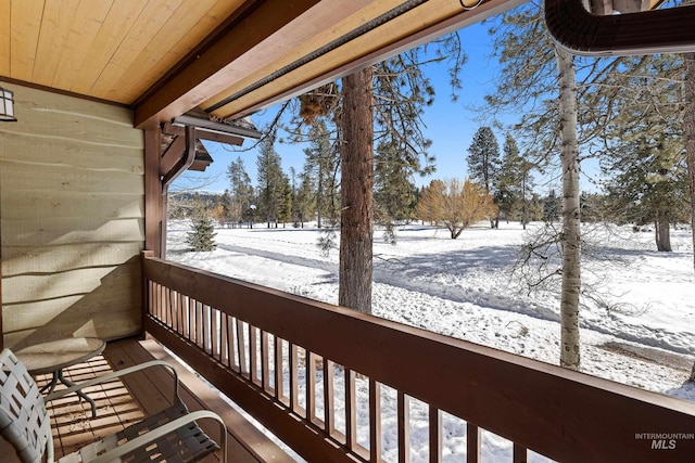 view of snow covered back of property