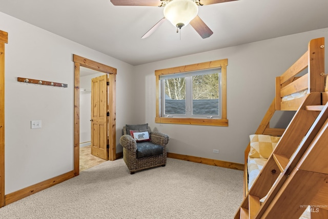 sitting room featuring carpet, baseboards, and ceiling fan