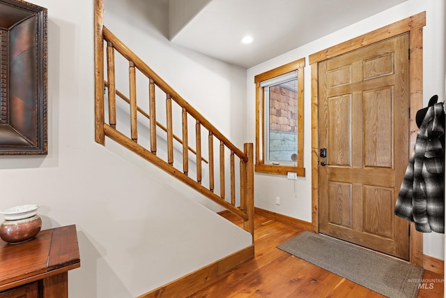 foyer entrance featuring stairs, baseboards, wood finished floors, and recessed lighting