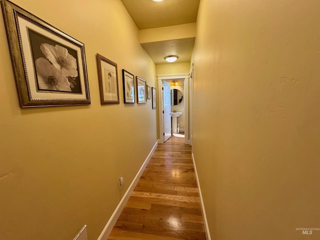 hallway with baseboards and wood finished floors