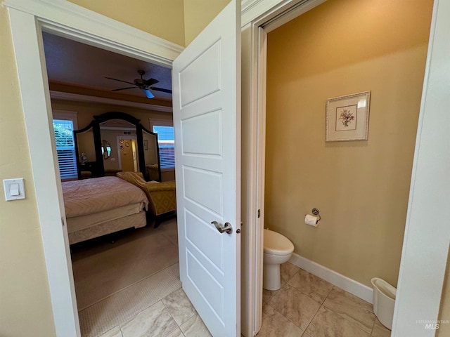 ensuite bathroom featuring baseboards, a ceiling fan, ensuite bath, and toilet
