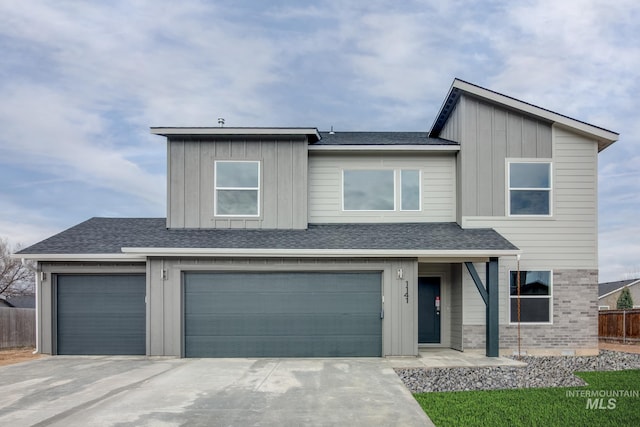 view of front of house featuring driveway, a shingled roof, board and batten siding, and fence