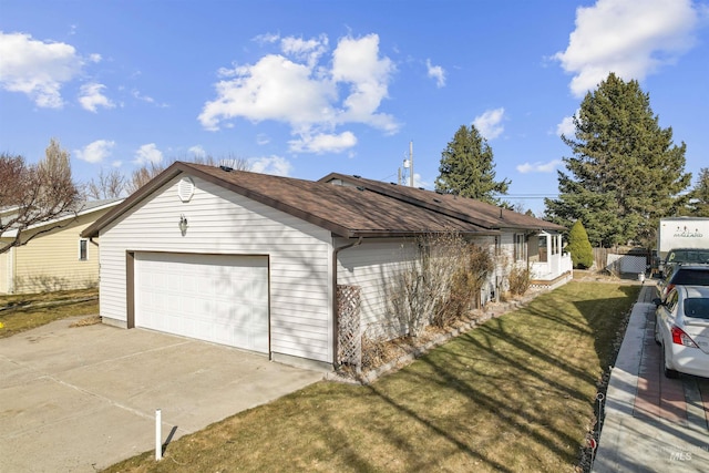 garage featuring roof mounted solar panels and concrete driveway