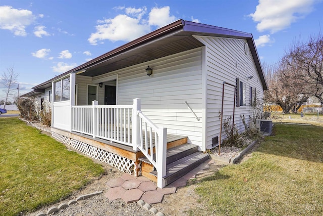 back of house featuring covered porch, a lawn, and cooling unit