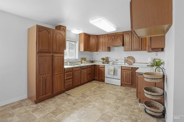 kitchen featuring white electric range, a sink, brown cabinetry, light countertops, and baseboards