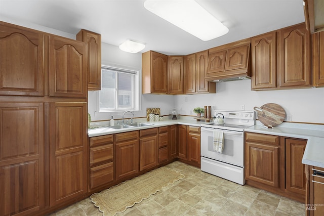 kitchen with brown cabinets, white electric stove, light countertops, and a sink