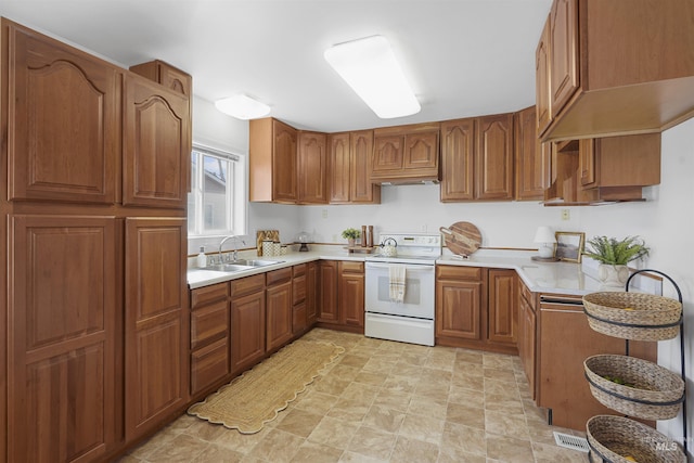 kitchen with brown cabinets, a sink, under cabinet range hood, white electric range oven, and light countertops