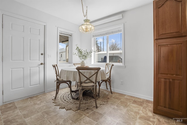 dining space featuring an inviting chandelier and baseboards