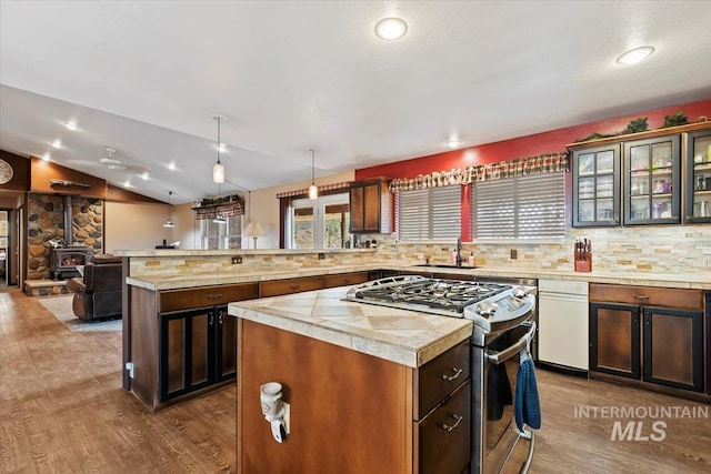 kitchen featuring a center island, a peninsula, stainless steel gas stove, and dark wood-style floors