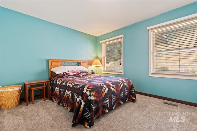 carpeted bedroom with visible vents and baseboards