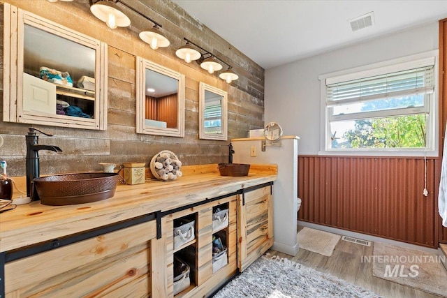 bathroom with wood finished floors, visible vents, vanity, and toilet
