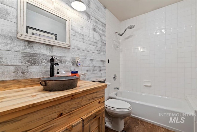bathroom with vanity, wood finished floors, tub / shower combination, and toilet