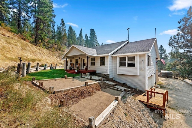rear view of house featuring fence and a shingled roof