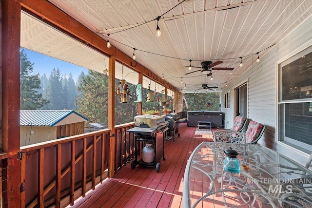 wooden terrace with a ceiling fan, a hot tub, and outdoor dining space