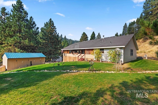 back of property featuring an outdoor structure and a yard